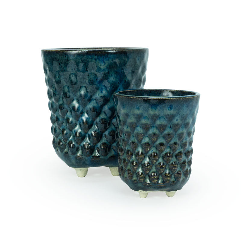 Two textured blue 3D printed ceramic dot patterned chalice planters on a white background