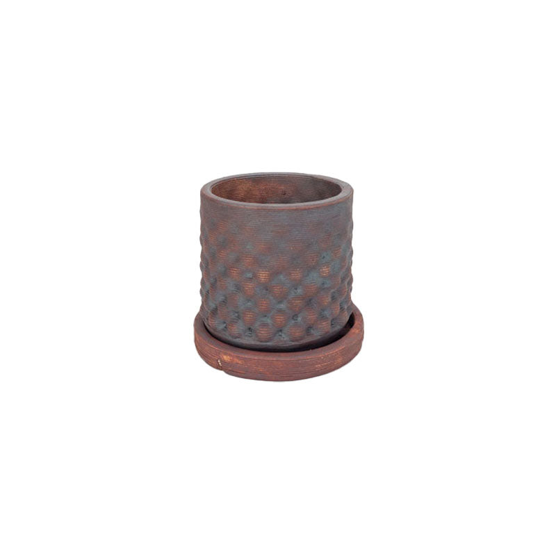Red iron oxide colored 3D printed ceramic planter with a dot pattern, on a tray on a white background