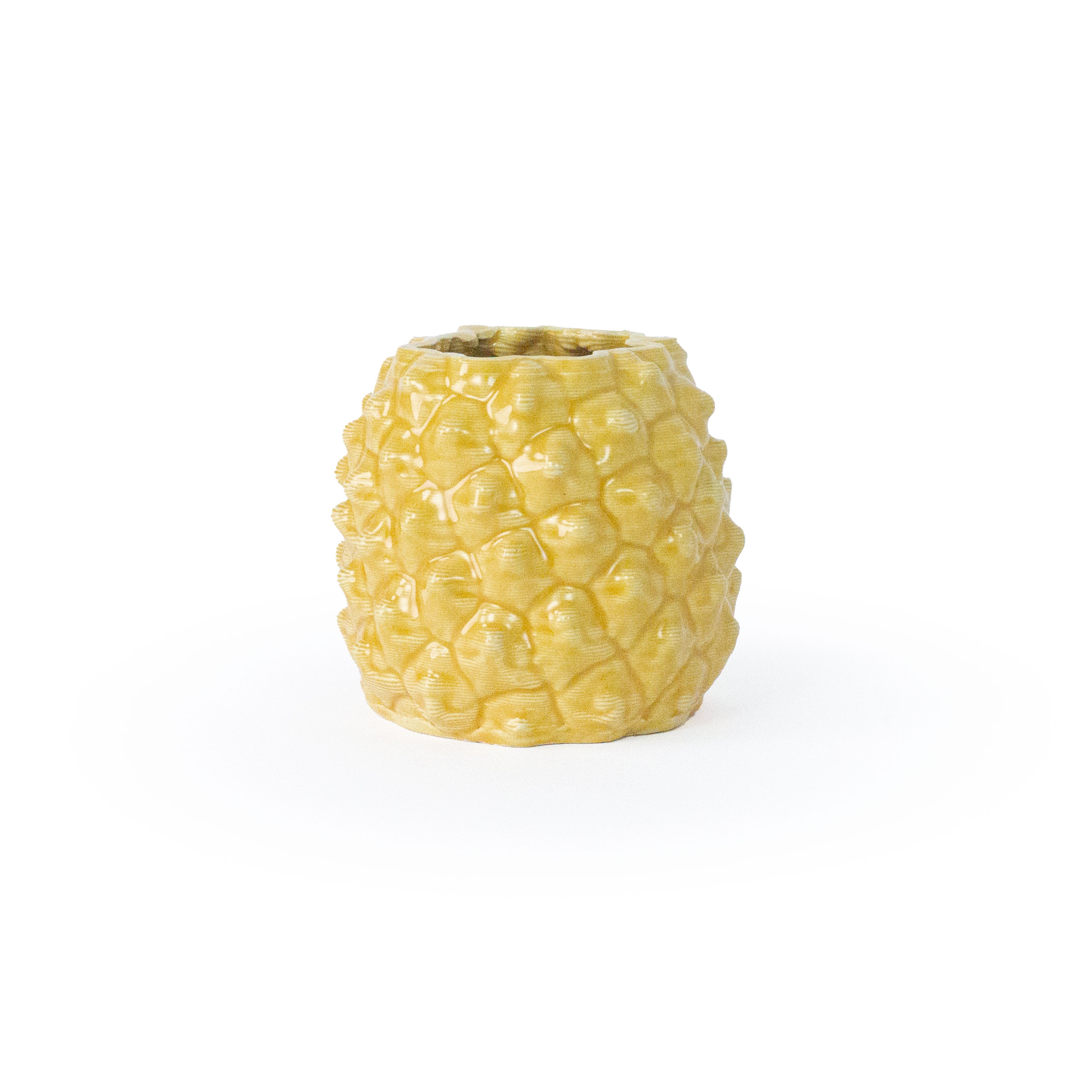 Marigold colored 3D printed ceramic planter with a pineapple pattern, on a white background