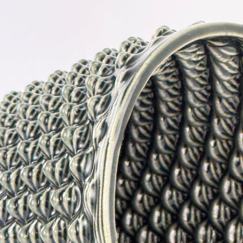 Close-up of a 3D printed ceramic planter with intricate designs