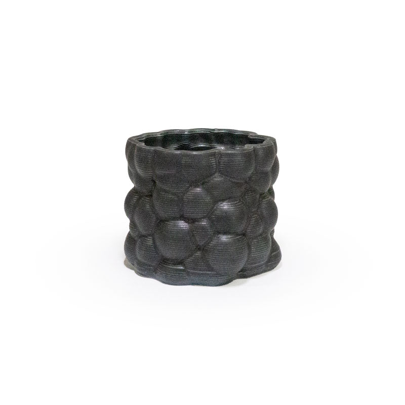 3D printed ceramic planter with a matte black bubble pattern on a white background