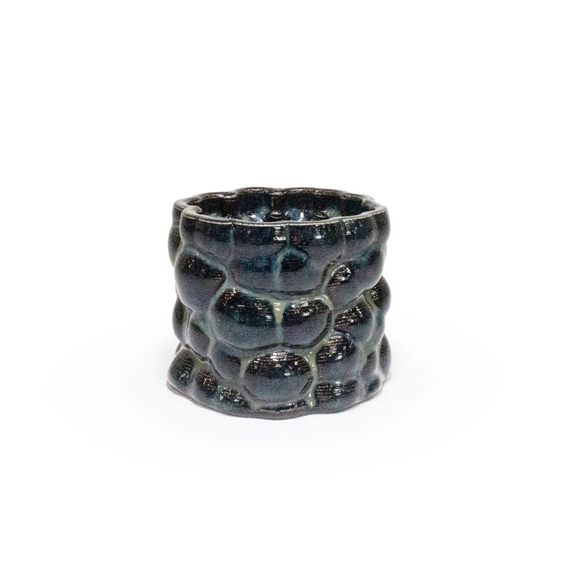 3D printed ceramic planter with a dark blue bubble pattern on a white background