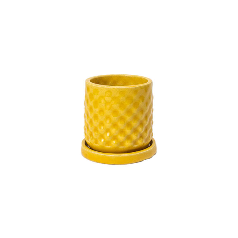 Marigold colored 3D printed ceramic planter with a dot pattern, with a tray on a white background