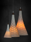 Three 3D printed porcelain pendant lights with textured, cone-shaped shades on a dark background