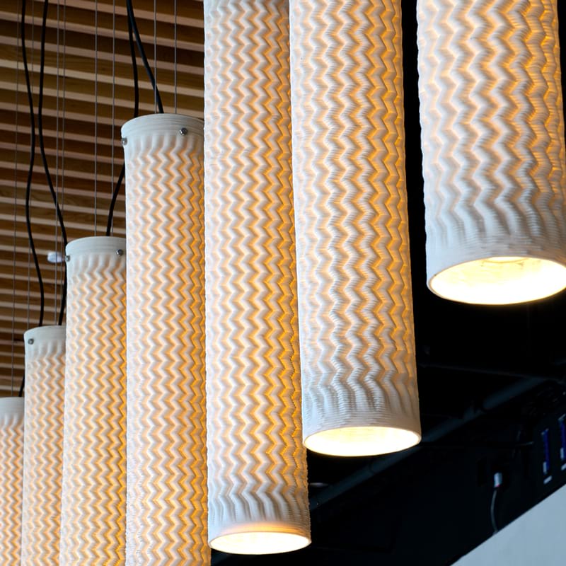 White textured 3D printed ceramic pendant lights hanging in a row