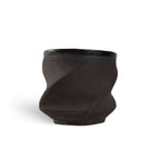 Black 3D printed ceramic cup with a textured eternity pattern, on a white background