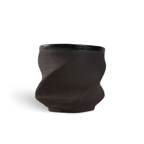 Black 3D printed ceramic cup with a textured eternity pattern, on a white background
