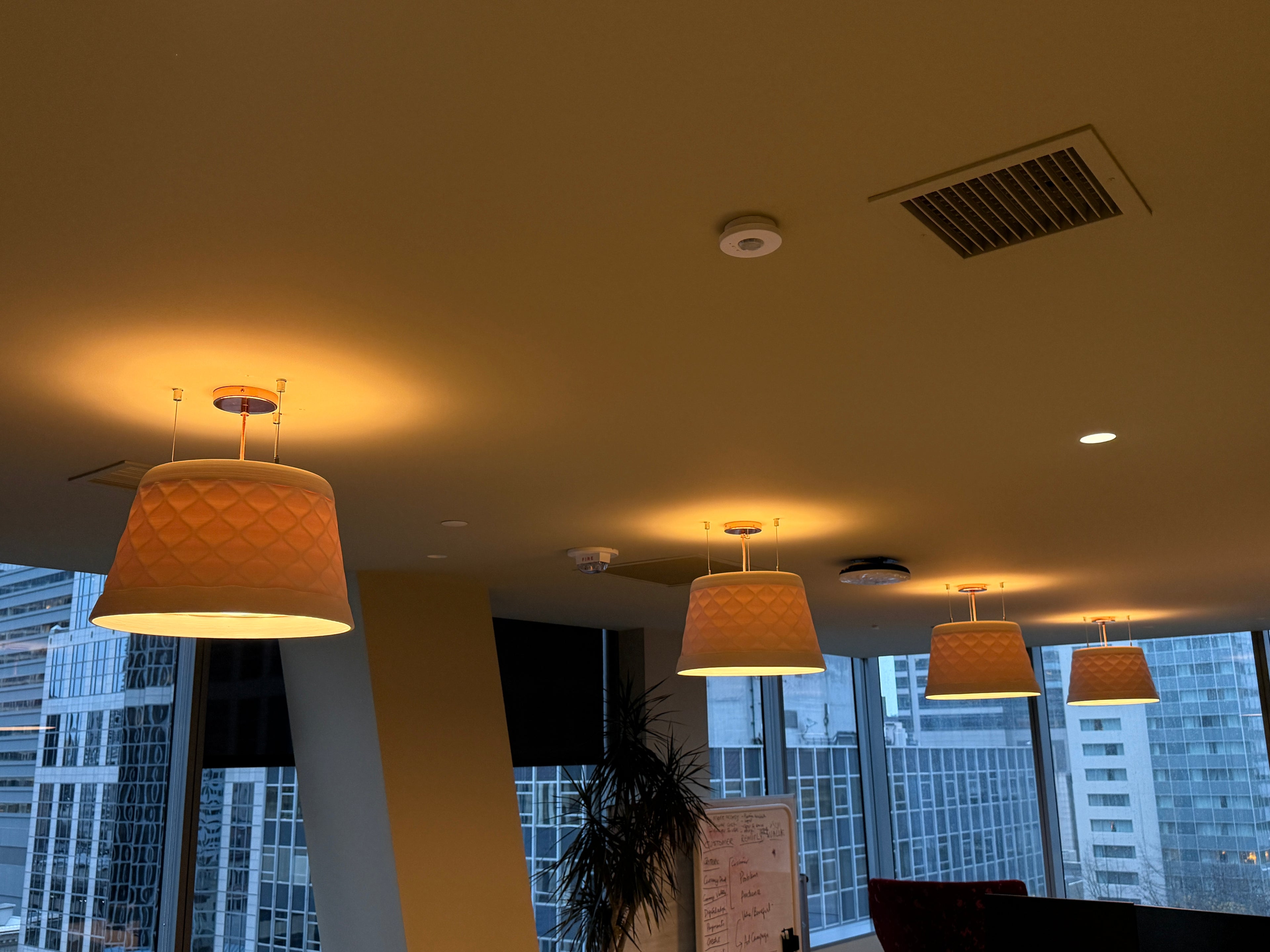 Ceiling with 3D printed ceramic pendant lights and cityscape view