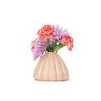 Light pink colored 3D printed ceramic bud vase with an urchin pattern, with colorful flowers on a white background